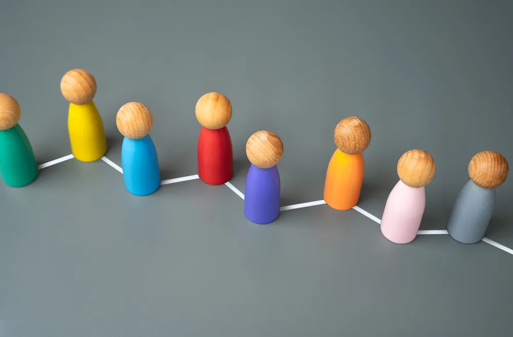 Bunte Holzfiguren in einer Reihe zeigen Vielfalt